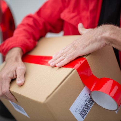 Caja con cinta roja de urgente